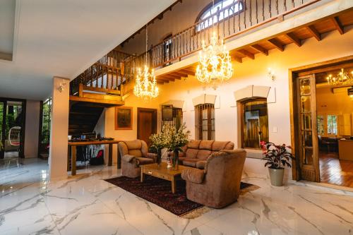 a living room with couches and a table and chandeliers at Estancia La Elena Hotel Boutique in Tandil