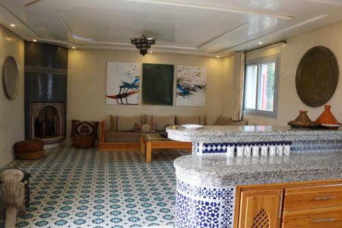 a living room with a fireplace and a living room with a table at Panoramic View Villa, 4 Bed, Pool in Mirleft
