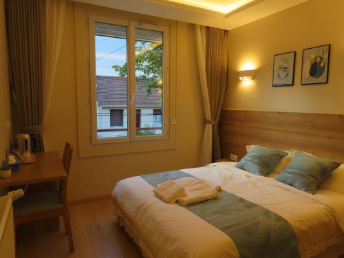 a bedroom with a bed with a window and a desk at Chambre à Bondy pour deux personnes in Bondy