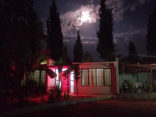 a house lit up at night with a full moon at Ngorongoro Villa and Restaurant in Karatu