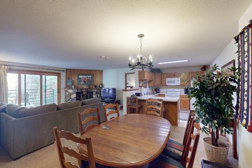 a kitchen and living room with a table and a couch at Snowdance Manor 205 in Keystone