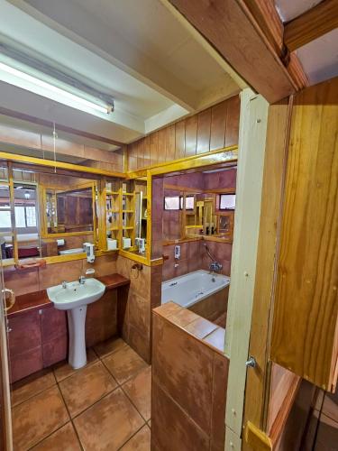 a large bathroom with a sink and a tub at Tudor Lodge Guest House in Johannesburg