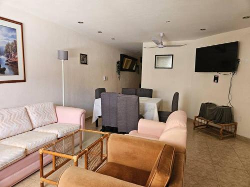 a living room with a couch and a tv at Bonito Depa céntrico in Jardines de la Hacienda