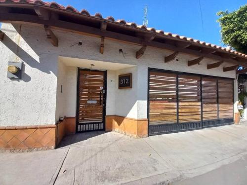 a house with two garage doors on it at Bonito Depa céntrico in Jardines de la Hacienda