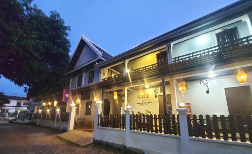 a building with a fence in front of it at Meunna Boutique Hotel in Luang Prabang