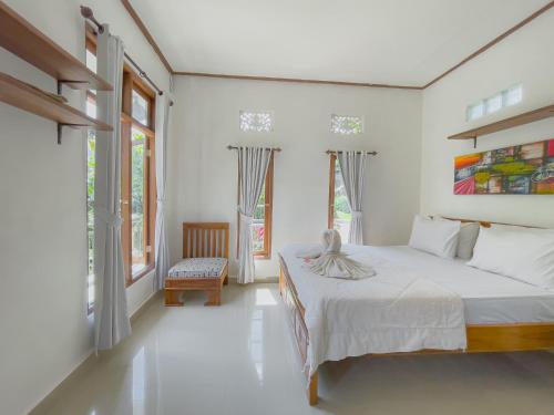 a white bedroom with a bed and a window at Surya Ubud View and Suites by EPS in Ubud