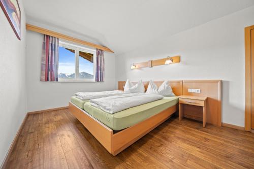 a bedroom with a bed and a window at Aparthotel Sunrise in Ramsau am Dachstein