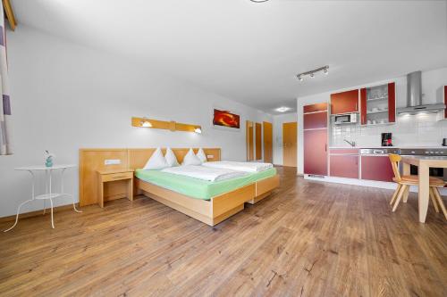 a large room with a bed and a kitchen at Aparthotel Sunrise in Ramsau am Dachstein