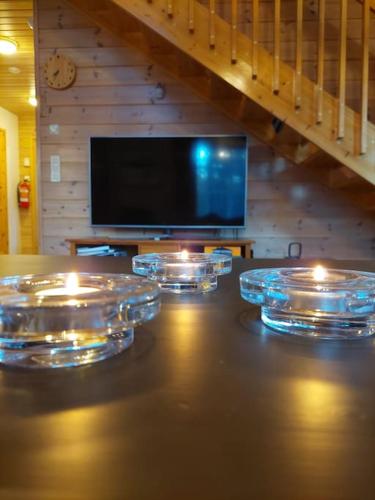 a living room with candles on a table with a tv at Kotoisa hirsihuvila Ylläksellä in Ylläsjärvi