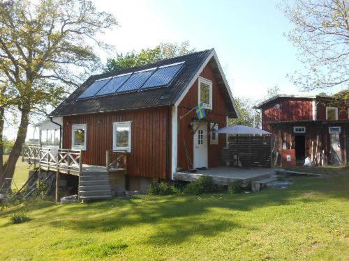 una pequeña casa con paneles solares en el techo en Awesome Home In Drottningskär With 0 Bedrooms, en Drottningskär