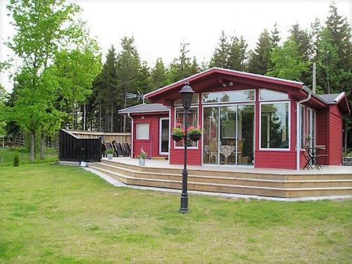 a red tiny house with a porch and a street light at Amazing Home In Värnamo With 2 Bedrooms in Värnamo