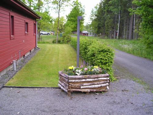 a wooden box with flowers next to a road at Amazing Home In Värnamo With 2 Bedrooms in Värnamo