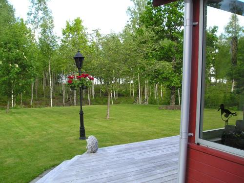 a porch with a lamp post with a bouquet of flowers at Amazing Home In Värnamo With 2 Bedrooms in Värnamo