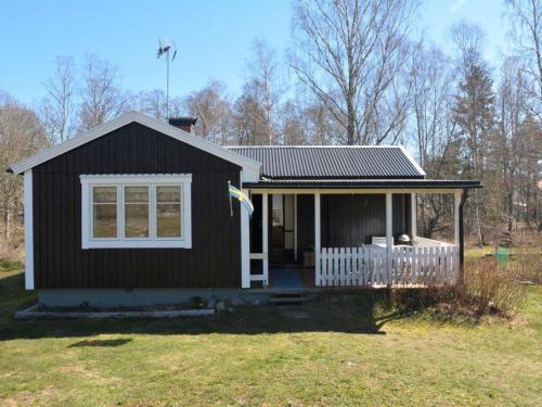 a small black house with a white window and a porch at Stunning Home In Oskarshamn With 2 Bedrooms And Wifi in Oskarshamn