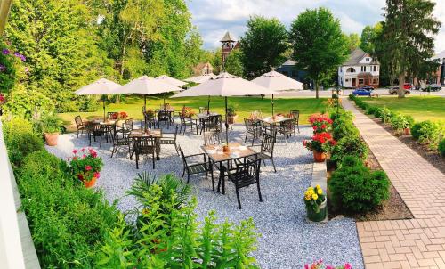 a group of tables and chairs with umbrellas in a garden at The Millerton Inn in Millerton