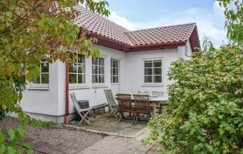 a white house with a table and chairs at 2 Bedroom Amazing Home In Kivik in Kivik