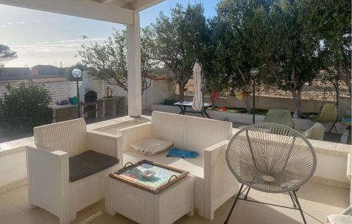 eine Terrasse mit weißen Möbeln sowie einem Tisch und Stühlen in der Unterkunft Cozy Home In Marina Di Ragusa in Marina di Ragusa