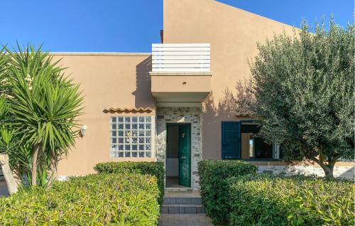 ein Haus mit einer grünen Tür und Bäumen in der Unterkunft Cozy Home In Marina Di Ragusa in Marina di Ragusa