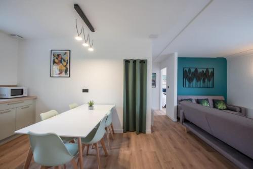 サリー・ド・ベアムにあるMaison moderne avec terrasse et parkingのキッチンとテーブルとソファのあるリビングルーム