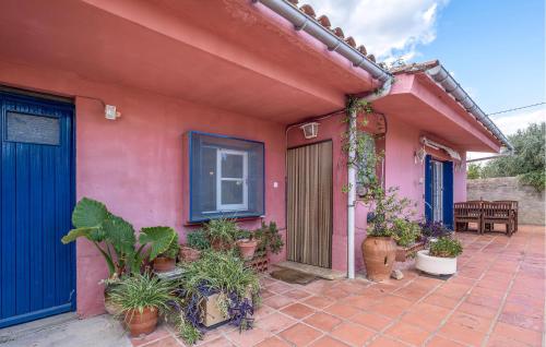 a pink house with potted plants on a patio at Awesome Home In Sant Miquel De Fluvià in San Miguel de Fluviá