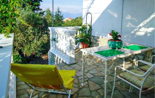 a patio with a table and chairs on a patio at 1 Bedroom Beautiful Apartment In Vrbnik in Vrbnik