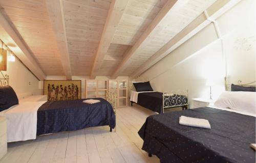 a attic room with two beds and a table at 3 Bedroom Stunning Apartment In Massa in Massa