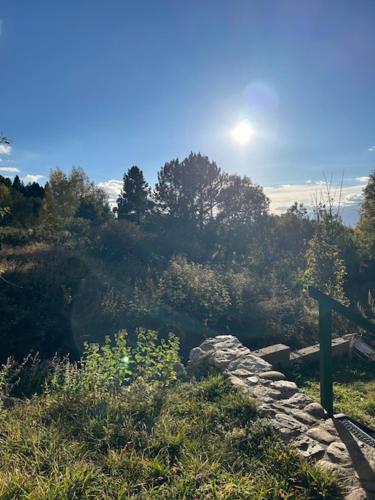 a stone wall in a field with the sun in the sky at Chalet avec terrasse proche pistes in Eyne