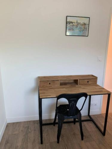a wooden desk with a chair next to a wall at Escapade à Combrit in Combrit