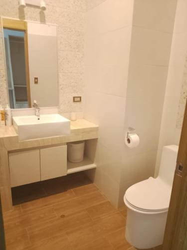 a white bathroom with a sink and a toilet at Hotel Vista Verde in Campoverde
