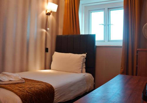a hotel room with a bed with a window at The Pier Hotel in Eastbourne