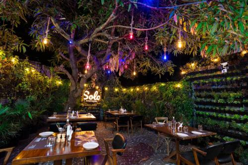 a restaurant with tables and a tree with lights at Solo Inn By Hawk Hospitality in Cochin