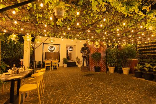 a patio with lights and tables and chairs at Solo Inn By Hawk Hospitality in Cochin