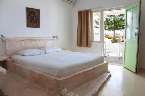 a bedroom with a bed and a door to a patio at Parasporos Village in Adamantas