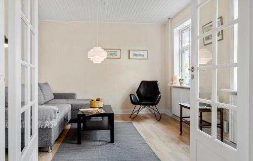 una sala de estar con un sofá y una silla en 3 Bedroom Gorgeous Home In Aakirkeby, en Åkirkeby