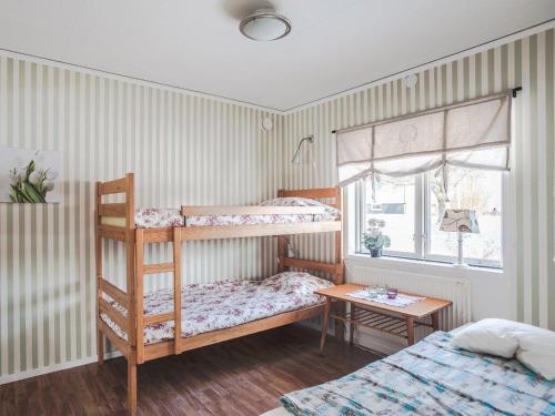 a bedroom with two bunk beds and a table at Awesome Home In Åseda With 2 Bedrooms And Wifi in Åseda