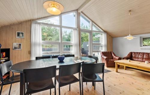a dining room with a table and chairs and a couch at Nice Home In Blåvand With Sauna in Blåvand