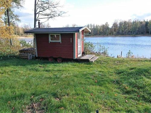 a small red shack on the side of a lake at Beautiful Home In Gamleby With 2 Bedrooms And Sauna in Gamleby