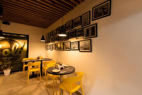 a dining room with two tables and yellow chairs at Solo Inn By Hawk Hospitality in Cochin