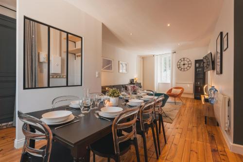 une salle à manger avec une table et des chaises noires dans l'établissement Au dessus des toits, à Cauterets
