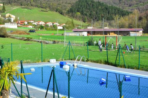 a swimming pool with a fence next to a field at Camping IZARPE in Aróstegui