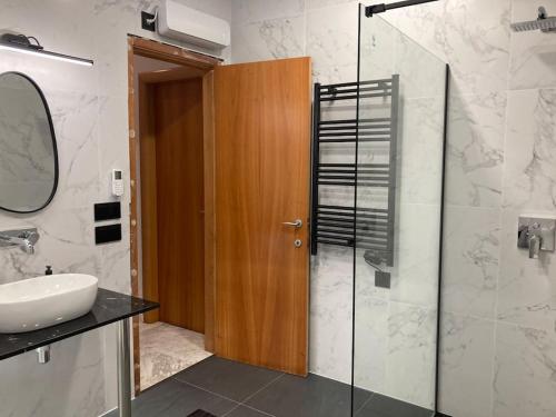a bathroom with a sink and a glass shower at House Seaviews Barcelona 22Km in Cabrils
