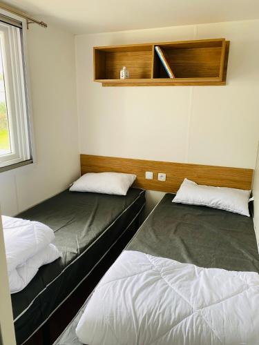 une chambre avec deux lits et une fenêtre dans l'établissement Domaine de Kerlann, à Pont-Aven