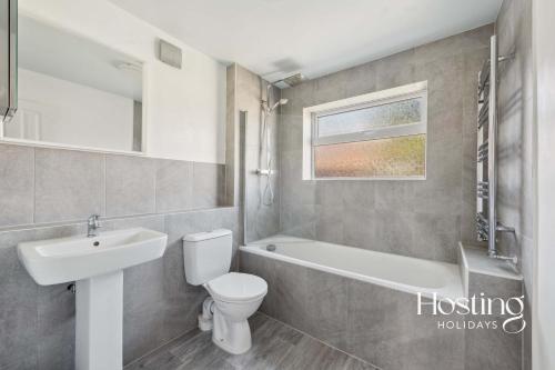 a bathroom with a sink and a toilet and a bath tub at Fern House - Cosy 3 bedroom house with garden in Henley on Thames