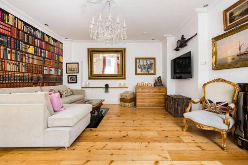 a living room with a white couch and a chandelier at Sherlocks in London