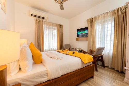 a bedroom with a large bed with yellow pillows at Solo Inn By Hawk Hospitality in Cochin