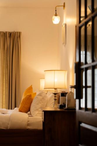 a bedroom with a bed and a lamp on a table at Solo Inn By Hawk Hospitality in Cochin