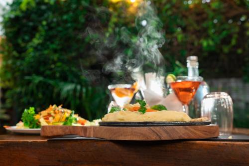 a plate of food sitting on a table with drinks at Solo Inn By Hawk Hospitality in Cochin