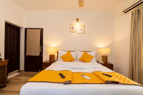 a bedroom with a bed with a yellow blanket on it at Solo Inn By Hawk Hospitality in Cochin