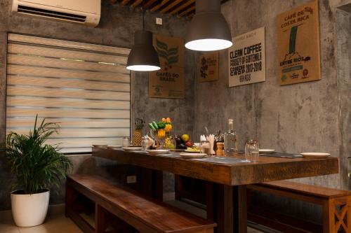 a dining room with a table and two benches at Solo Inn By Hawk Hospitality in Cochin