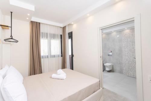 een witte slaapkamer met een douche en een bed bij Ionas Apartments 1 in Nea Skioni